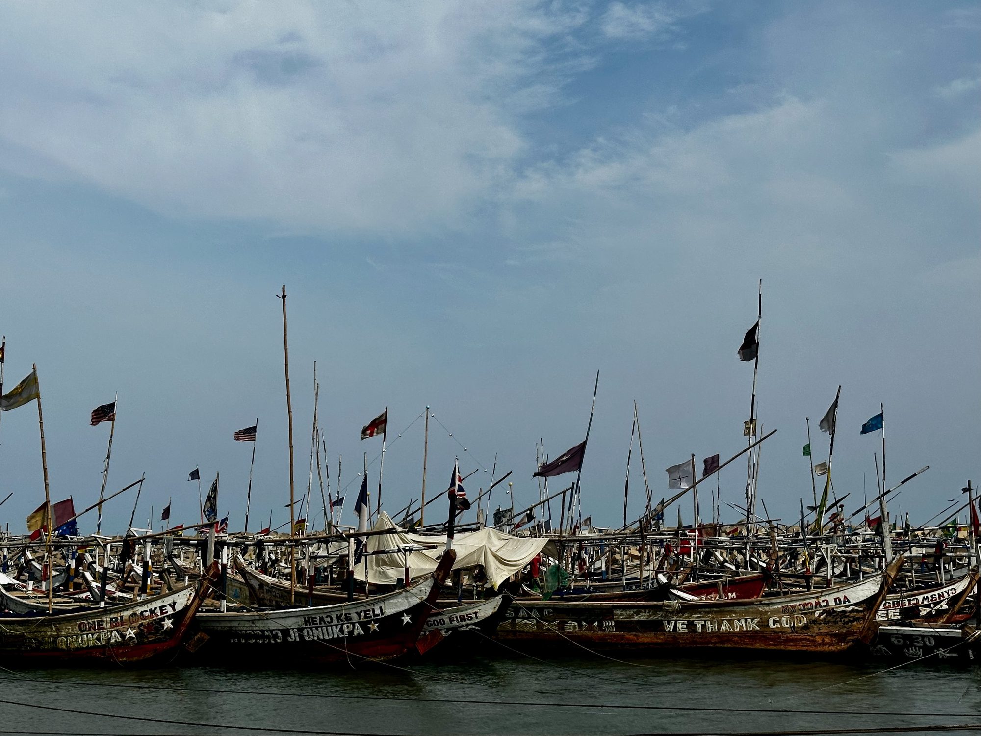 Wooden fishing boats flying flags, moored at the coast