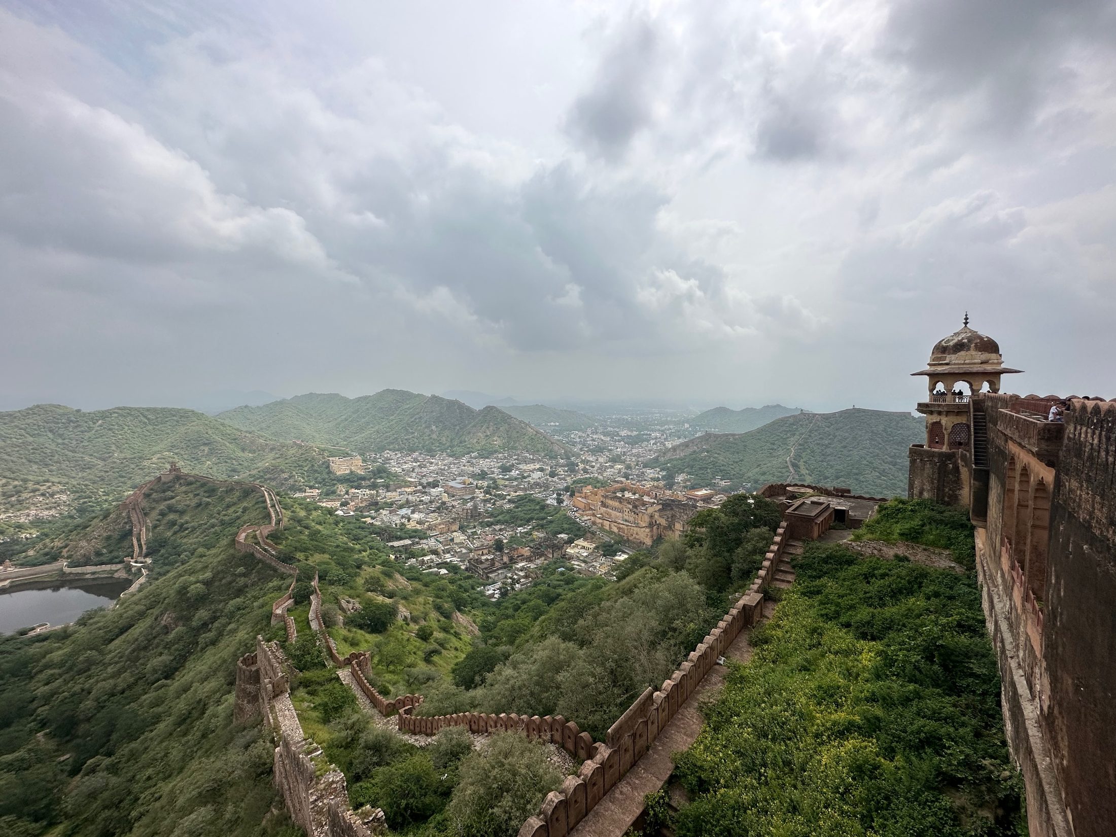 Fort ramparts winding along a green ridge above the city
