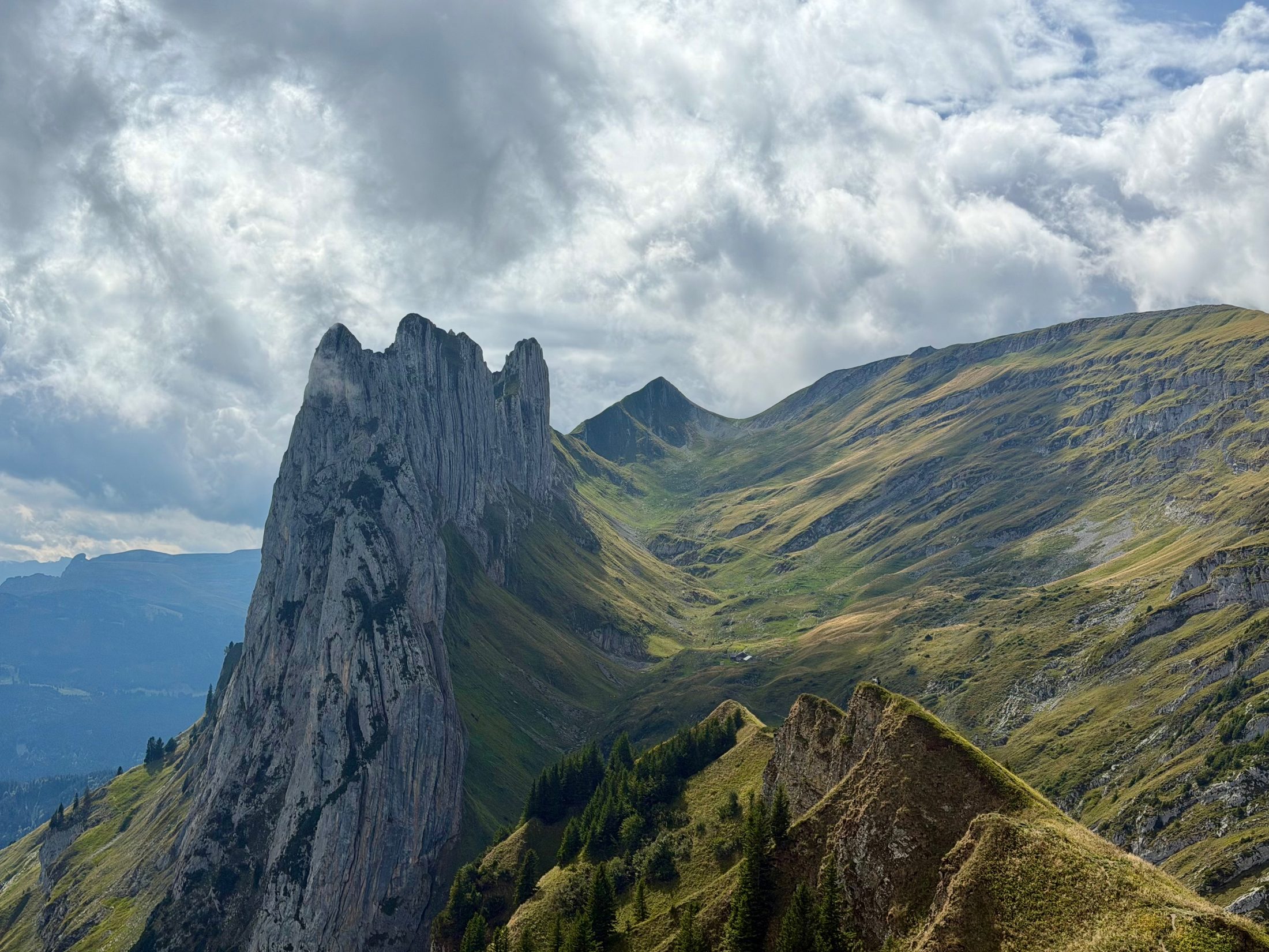 A jagged limestone ridge above a green alpine valley